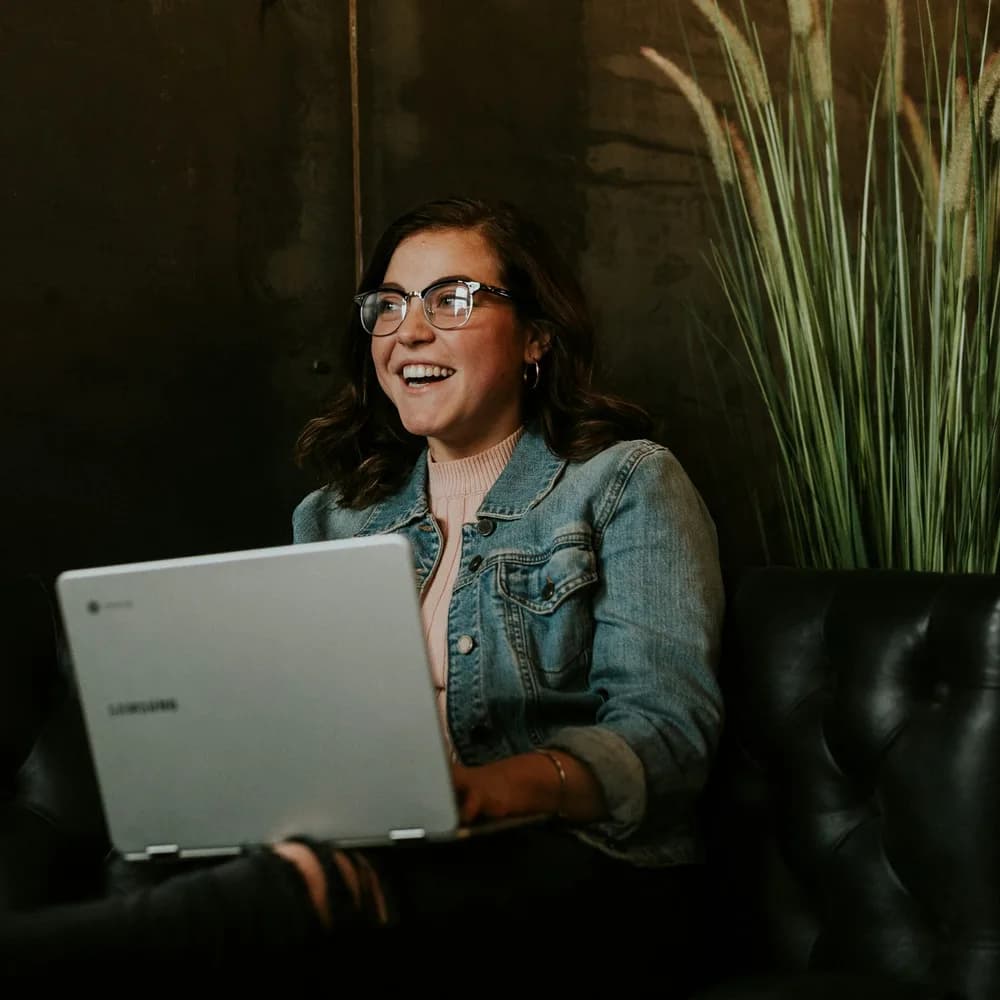 Une cliente souriante qui commande depuis son ordinateur portable
