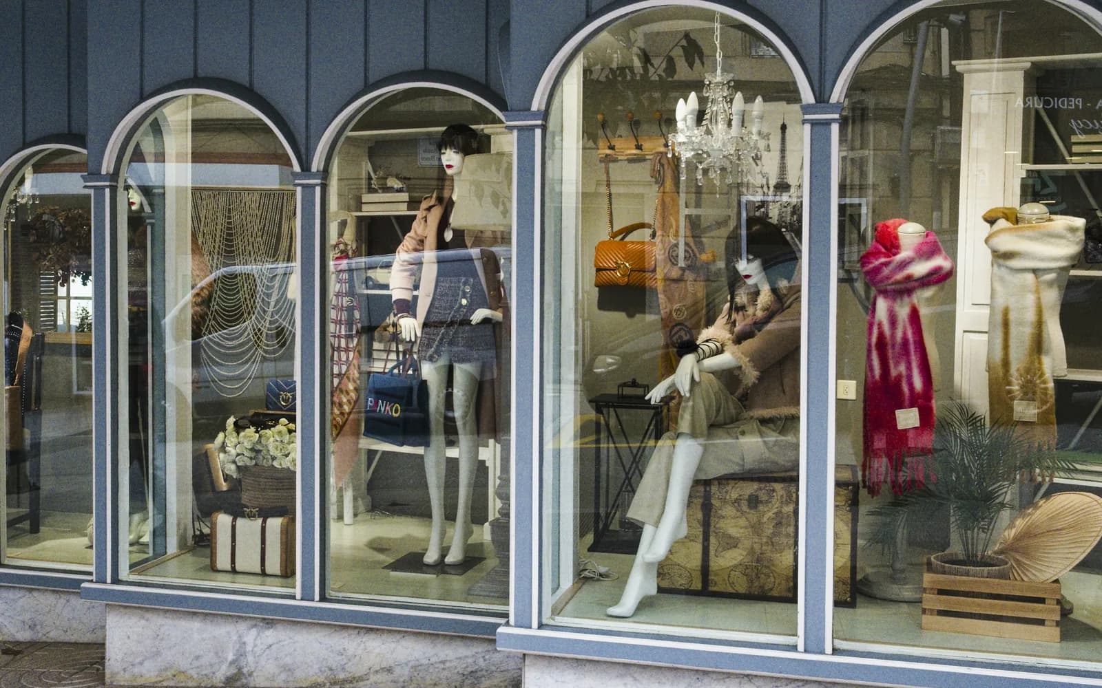 Vitrines en arcades d'une boutique, avec mannequins et accessoires exposés